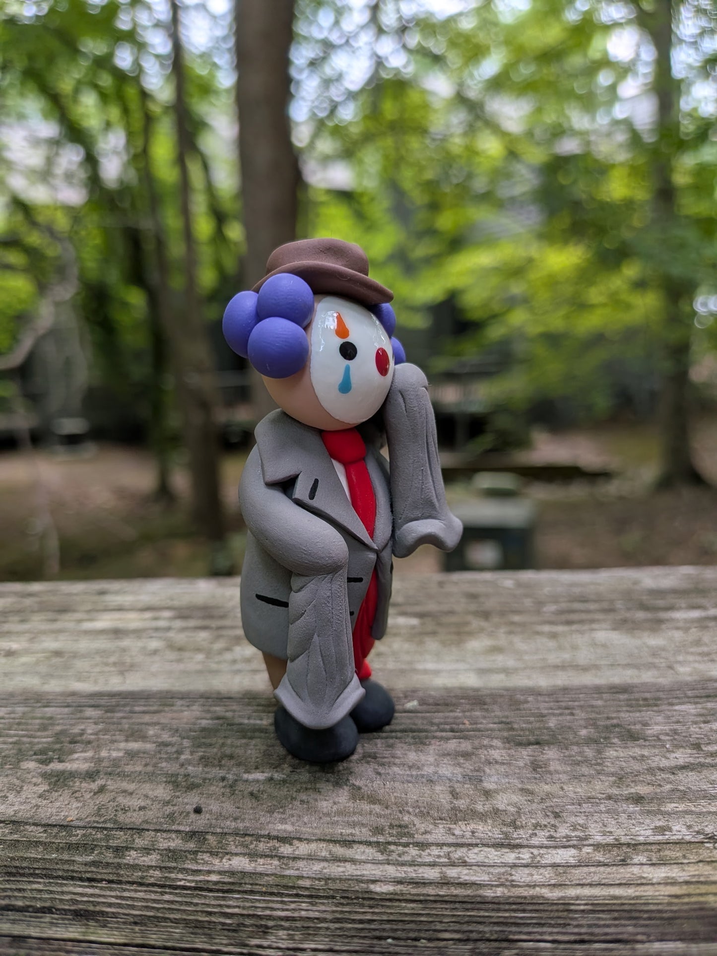 A view of the front right side of a clown in oversized business attire. It shows his funny, comedically long sleeves that almost touch the ground.