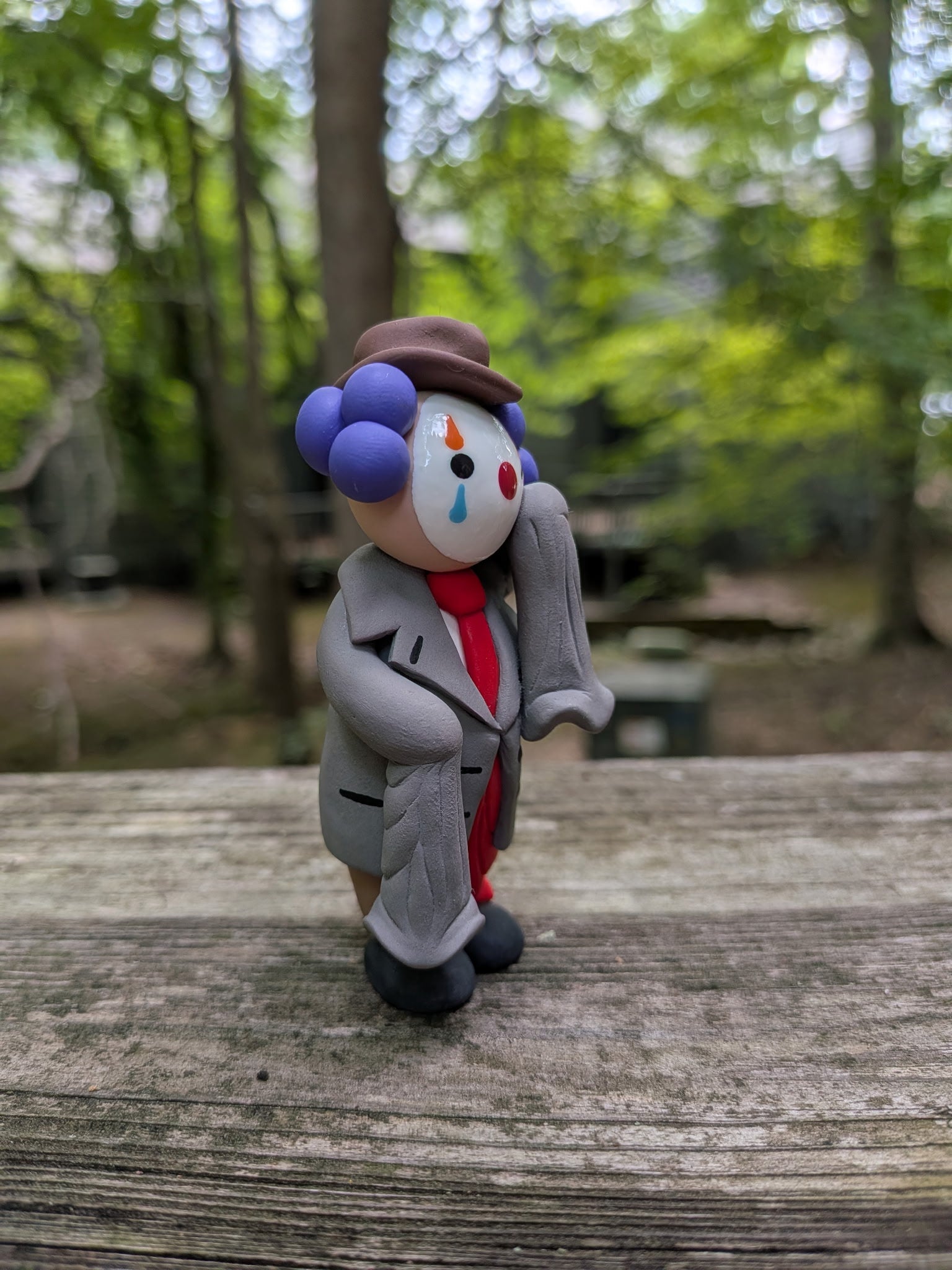 A view of the front right side of a clown in oversized business attire. It shows his funny, comedically long sleeves that almost touch the ground.